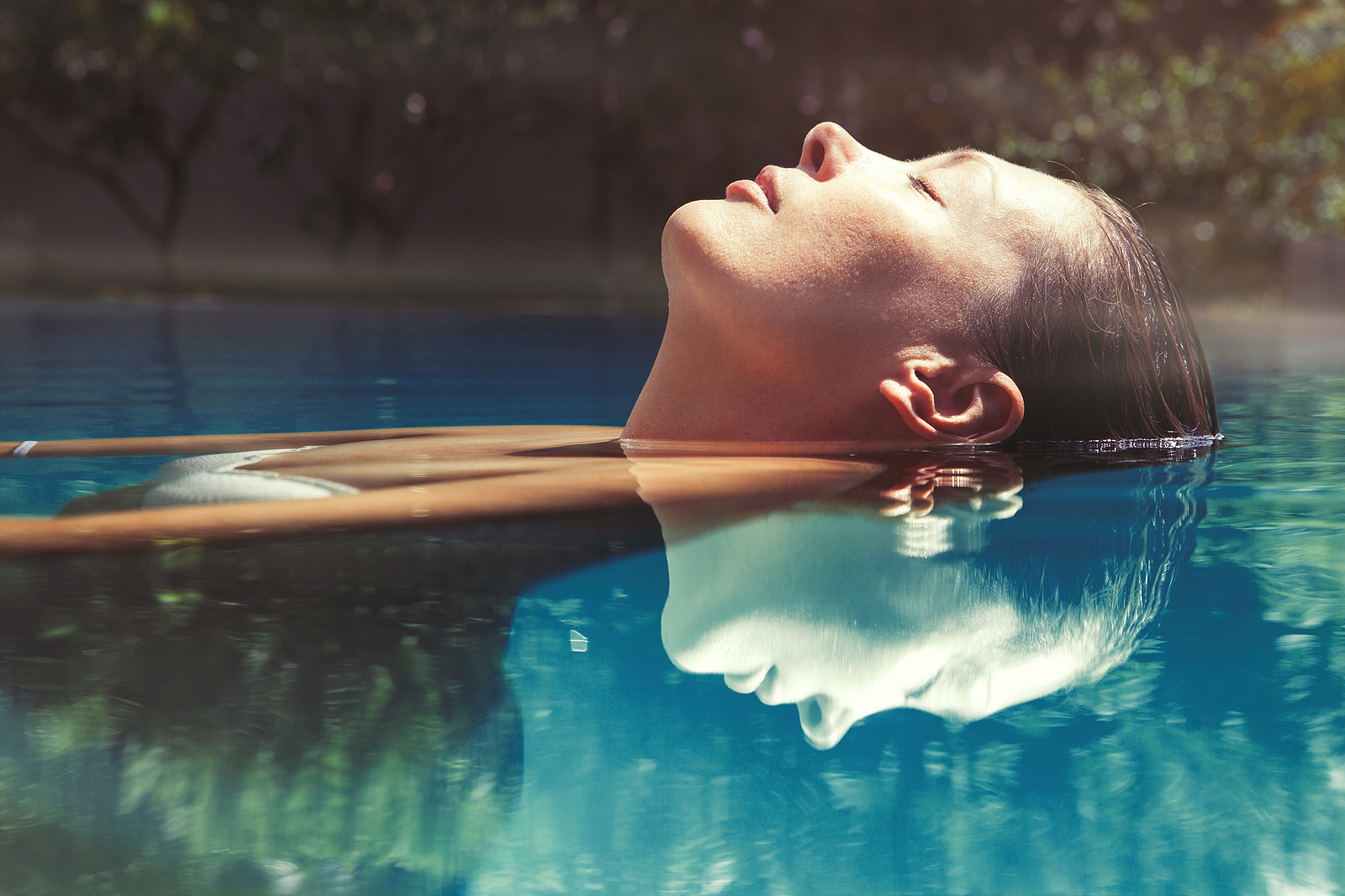 woman floating on her back in a swimming pool